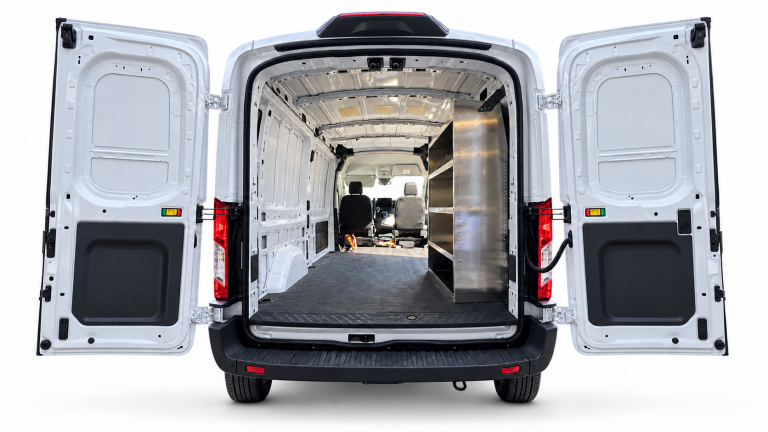 Ford Transit aluminum shelving unit installed on the passenger side, viewed through the open rear doors.